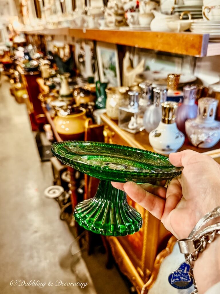 vintage small green cake stand in hand at antique store in Knowlton, Quebec.