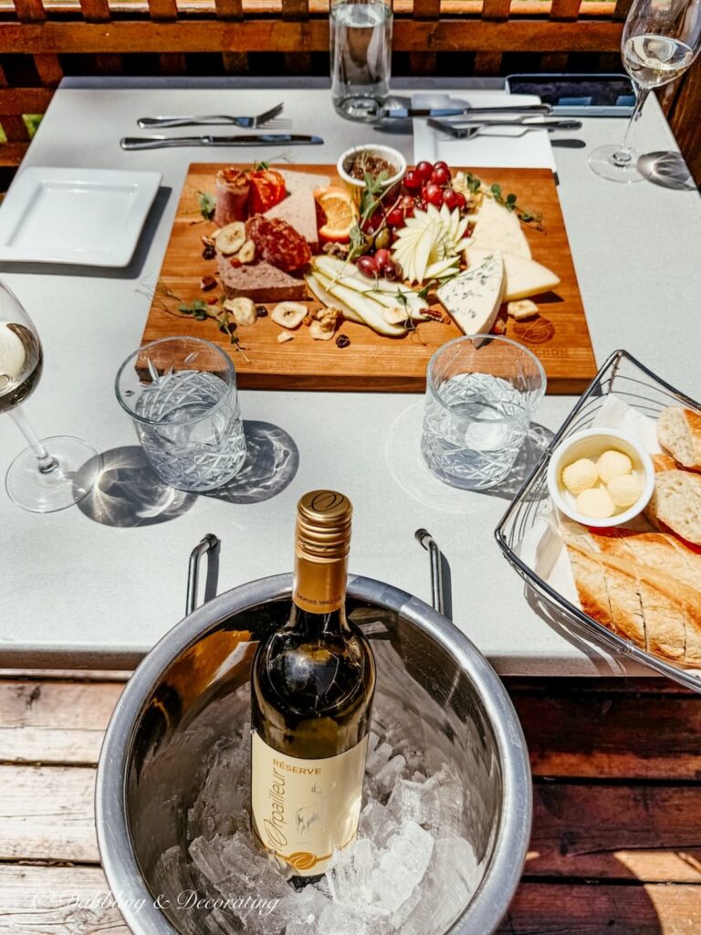 Charcuterie board with a bottle of wine served at the outdoor restaurant at Vignoble de l'Orpailleur in Dunham, Quebec.