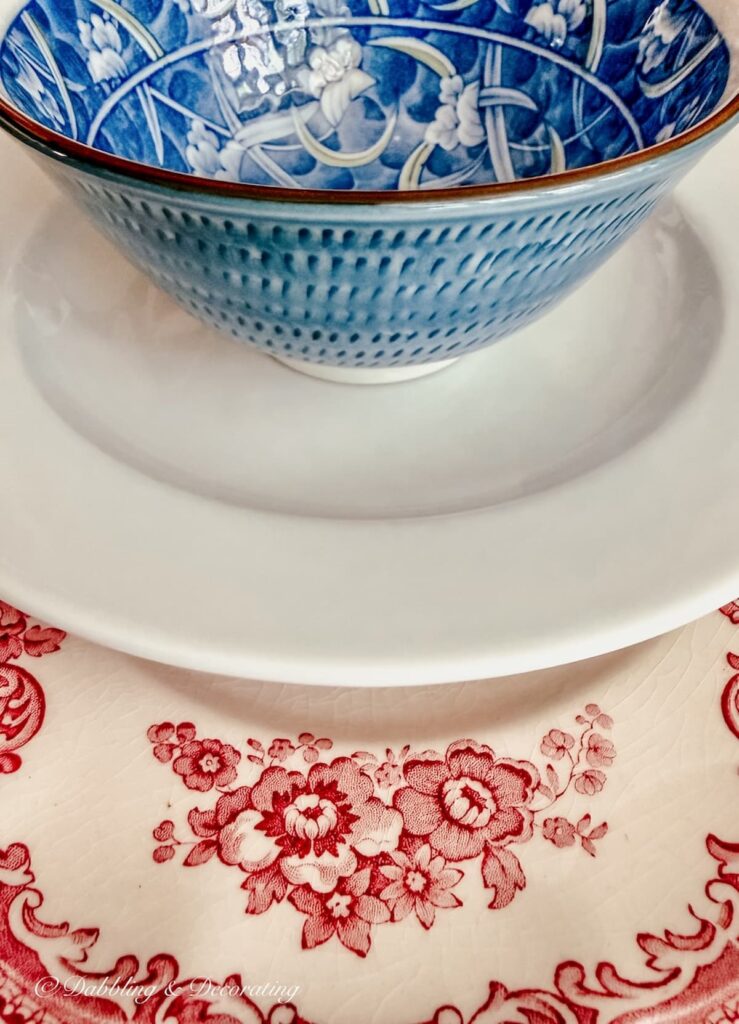 Layered vintage dishes in red, white, and blue close up.