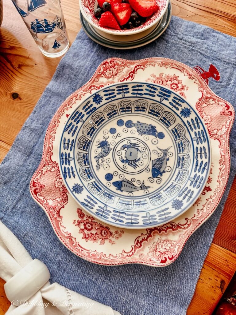 Johnson Brothers red and white platter layered with vintage blue and white bowl on denim place mats for summer table ideas.
