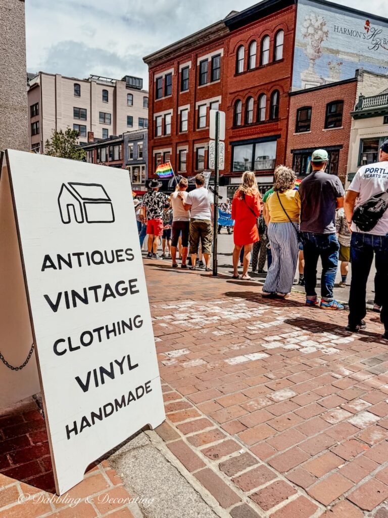 Antiques Vintage Clothing Vinyl sign outside Open House Portland, Maine with crowds of people outdoors.