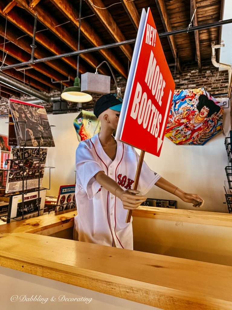 Mannequin in antique store dressed in a red sox jersey with sign that says More Downstairs in antique decorating ideas.