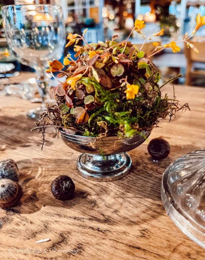 Silver sherbert bowl with dried fall flower centerpiece display in vintage booth display.