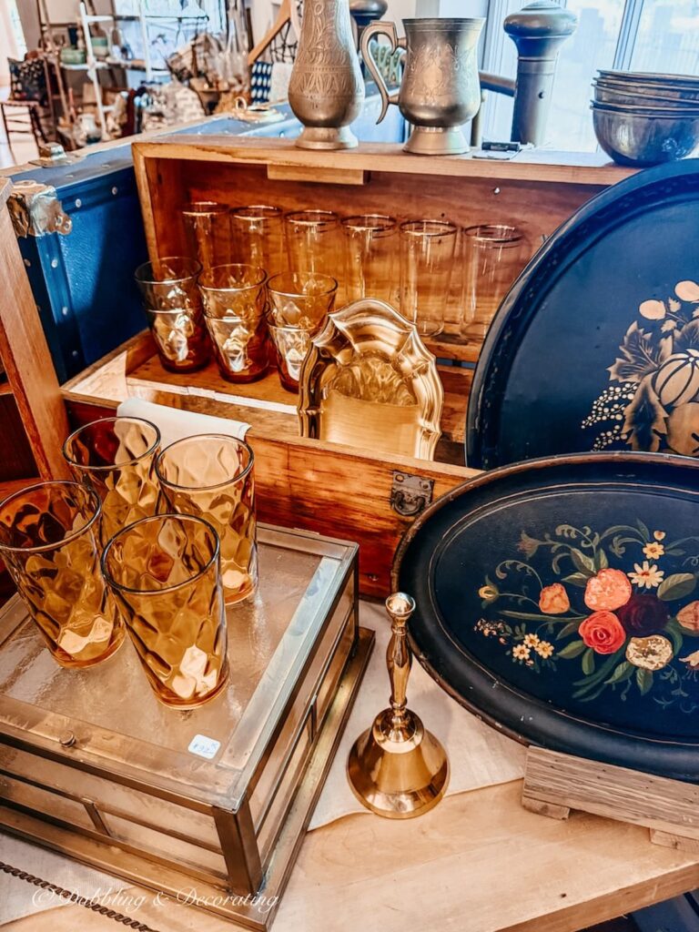 Vintage amber glassware with antique black trays styled in a fall vintage booth display.