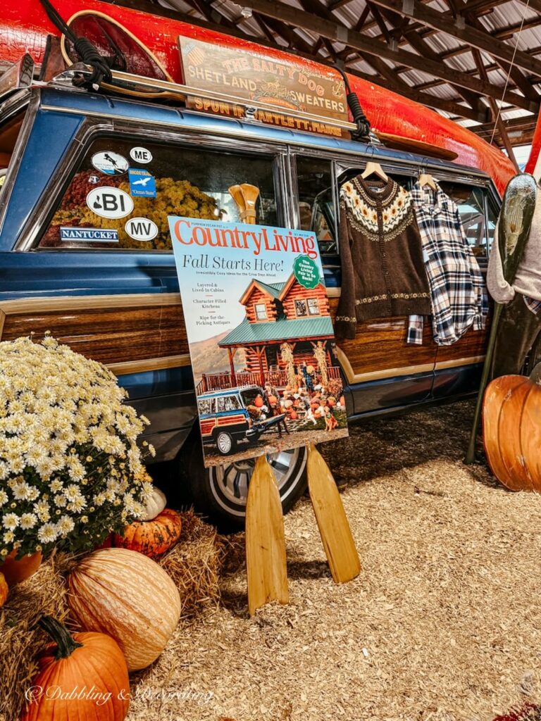 Vintage Wagoneer styled in a vintage fall booth with pumpkins, mums, Red Canoe, flannel sweaters and shirts, and Country Living Fair sign.