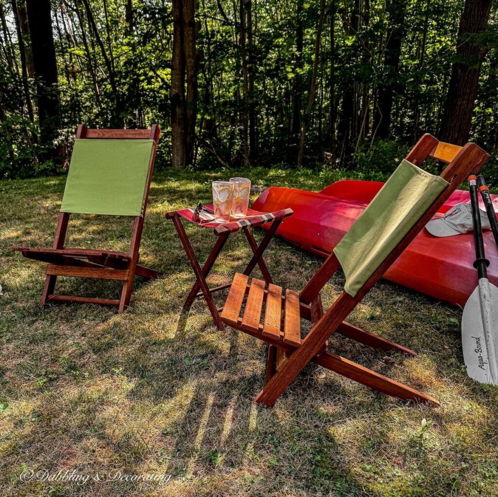 Vintage backyard camp chair set up with kayaks, retro wooden chairs and stool.