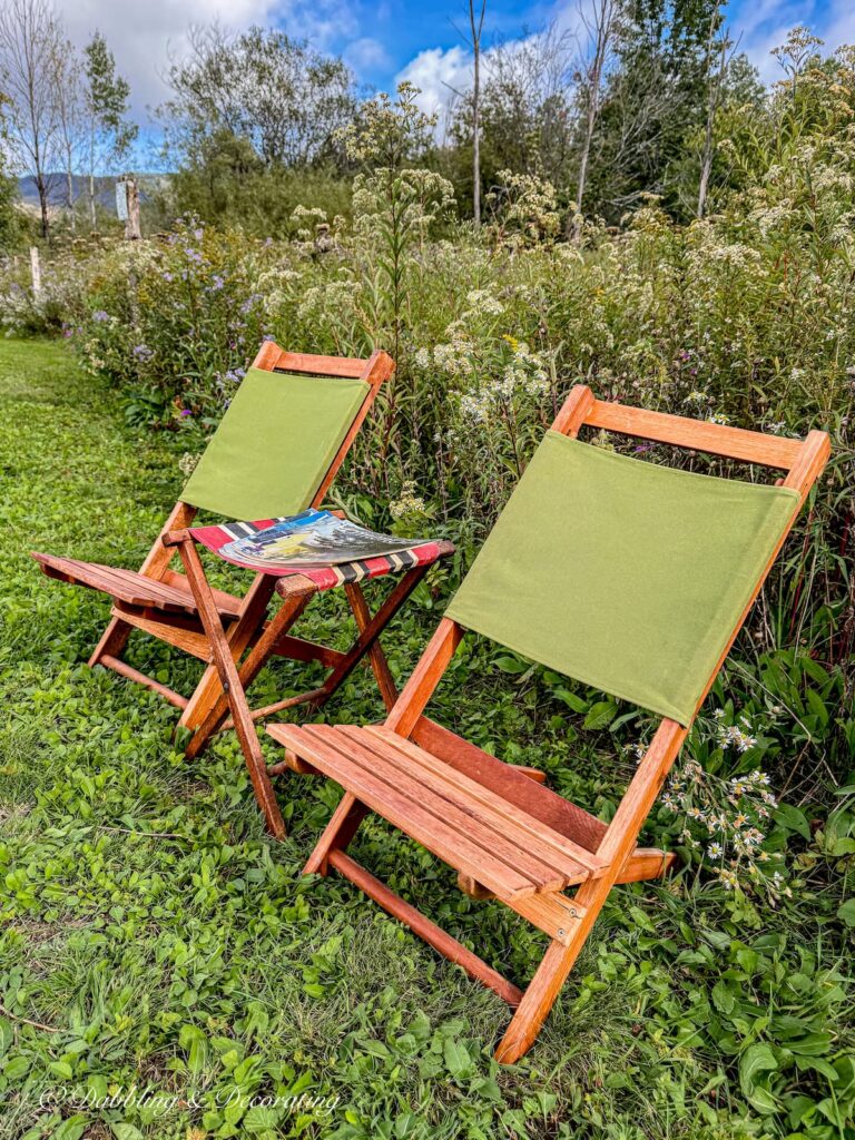 two retro green teak camp chairs with red canvas stool at a campground in Smuggler's Notch during the fall Vermont season.