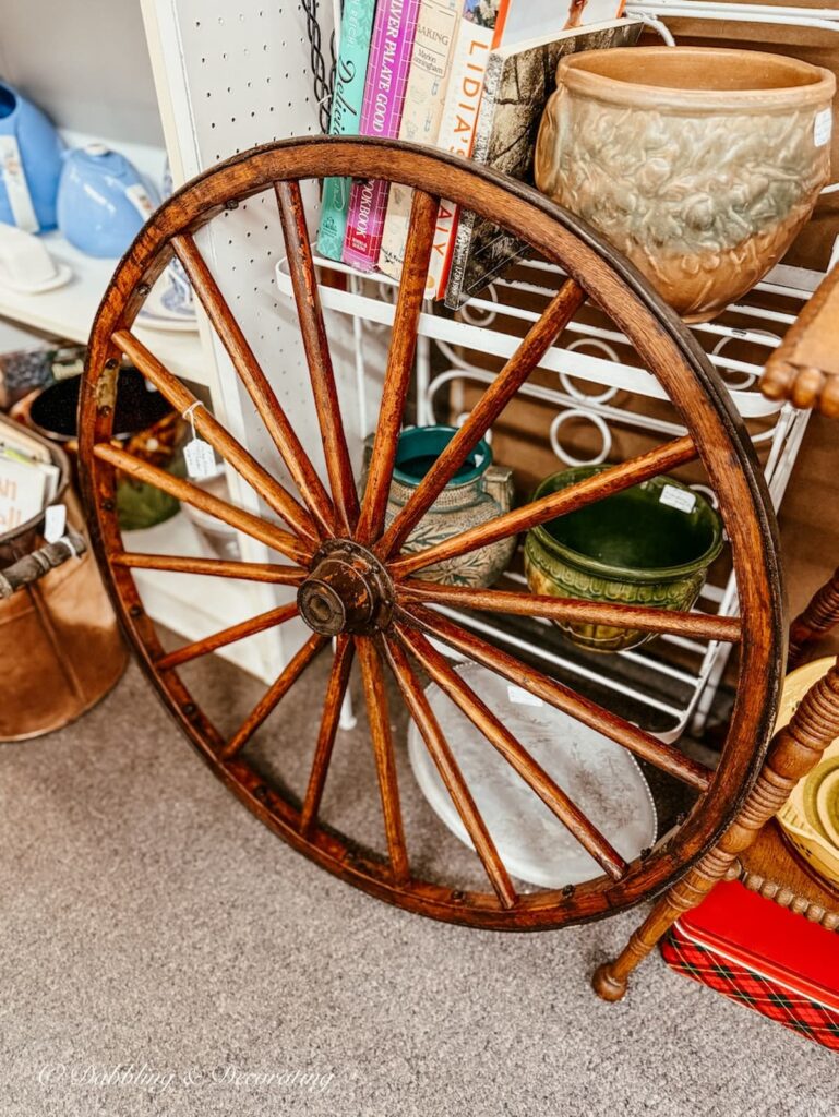 Beautifully stained old wagon wheel resting inside an antique shop in New England.
