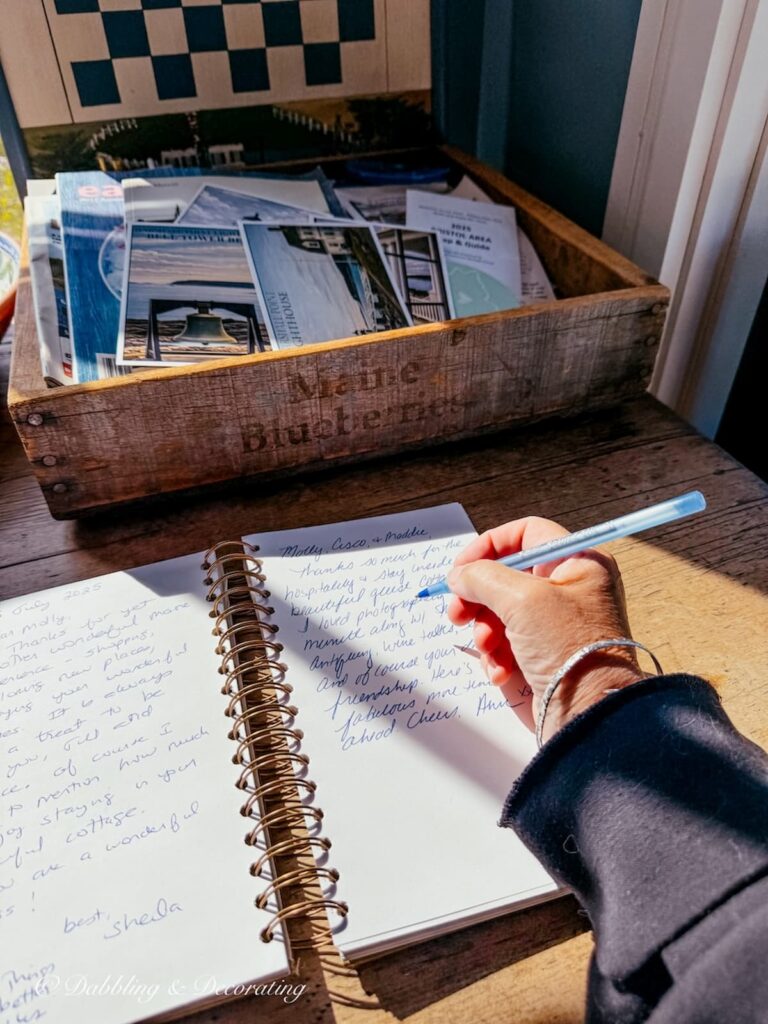 Leaving a note in a guest book of a guest cottage in a home in Maine.