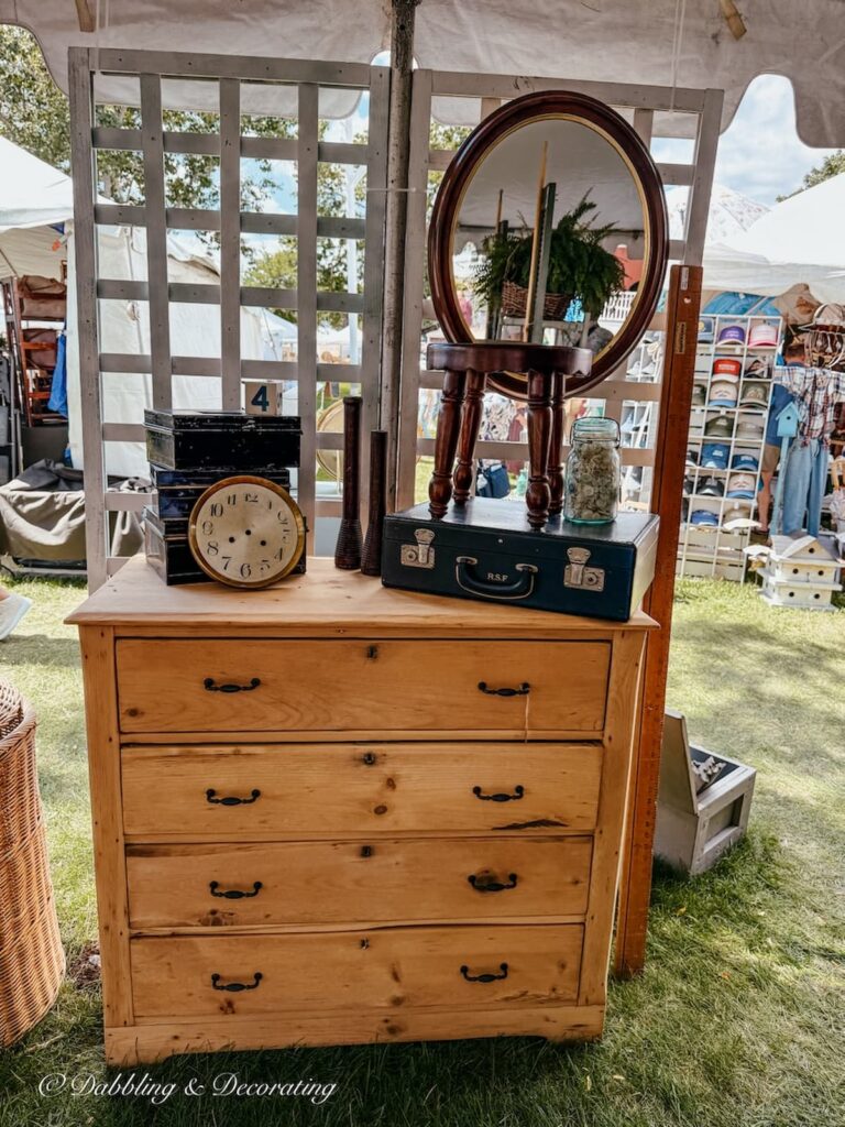 Vintage wooden dresser display in antique booth outdoors under tent at Vintage Bazaar New England.