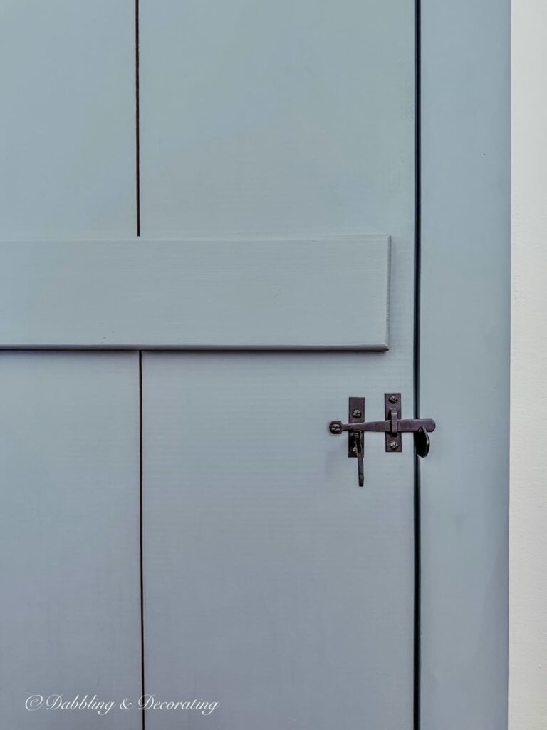 Old-fashioned colonial style bedroom door painted in a custom blue-gray historic paint color next to a Simply white wall paint color.