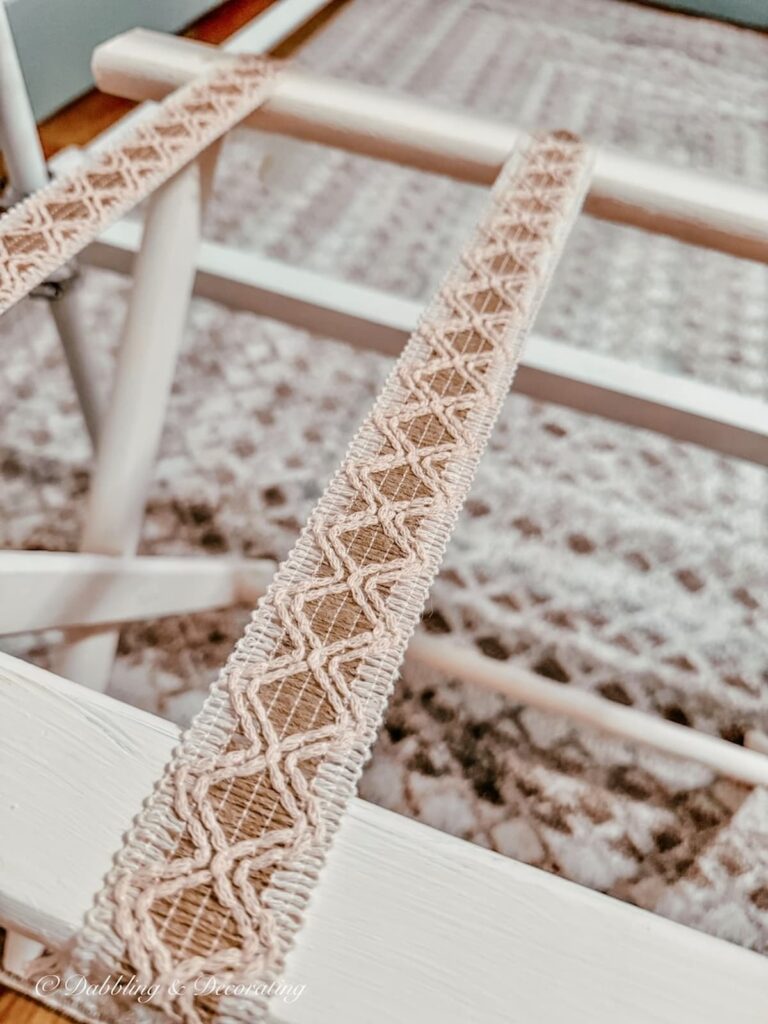 Jute and neutral ribbon on DIY folding luggage rug makeover in bedroom close up.