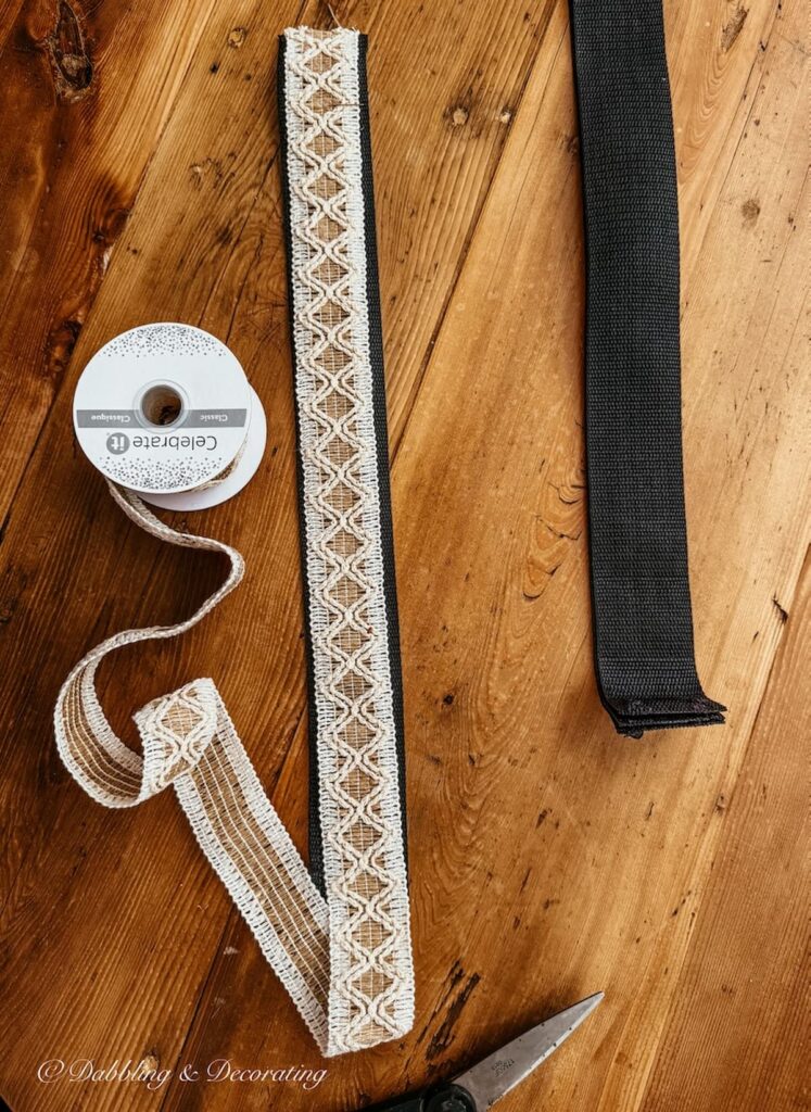 Ribbon lying on top of old luggage rack webbing for measuring and cutting for a DIY makeover.