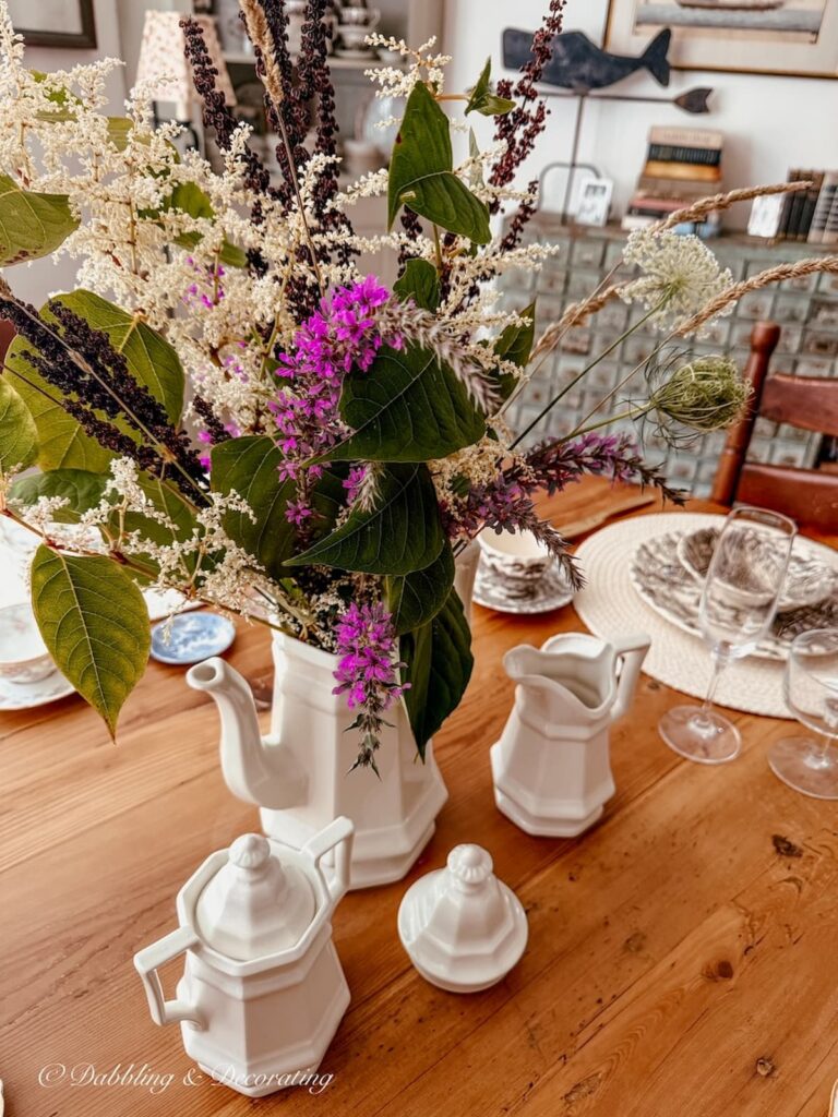 Summer into fall foraged table centerpiece in white vintage teapot on dining room table.