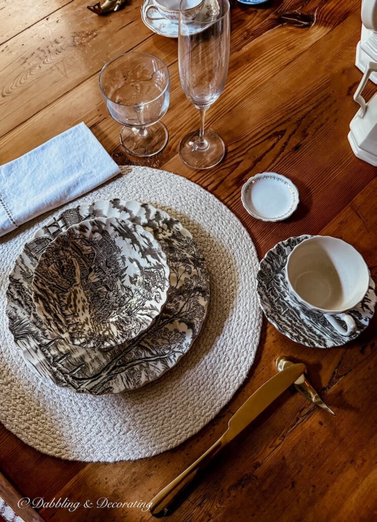 Brown and white transferware family heirloom place setting on vintage table setting.