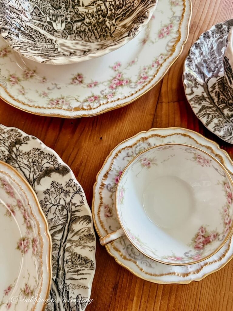 Setting a table with family heirlooms; brown and white transferware and pink and gold Limoges dishes layered for summer into fall table setting.