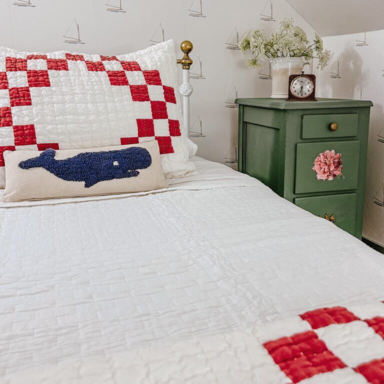 DIY painted green nightstand next to small guest room attic twin antique wrought iron bed with red and white bedding and whale pillow.