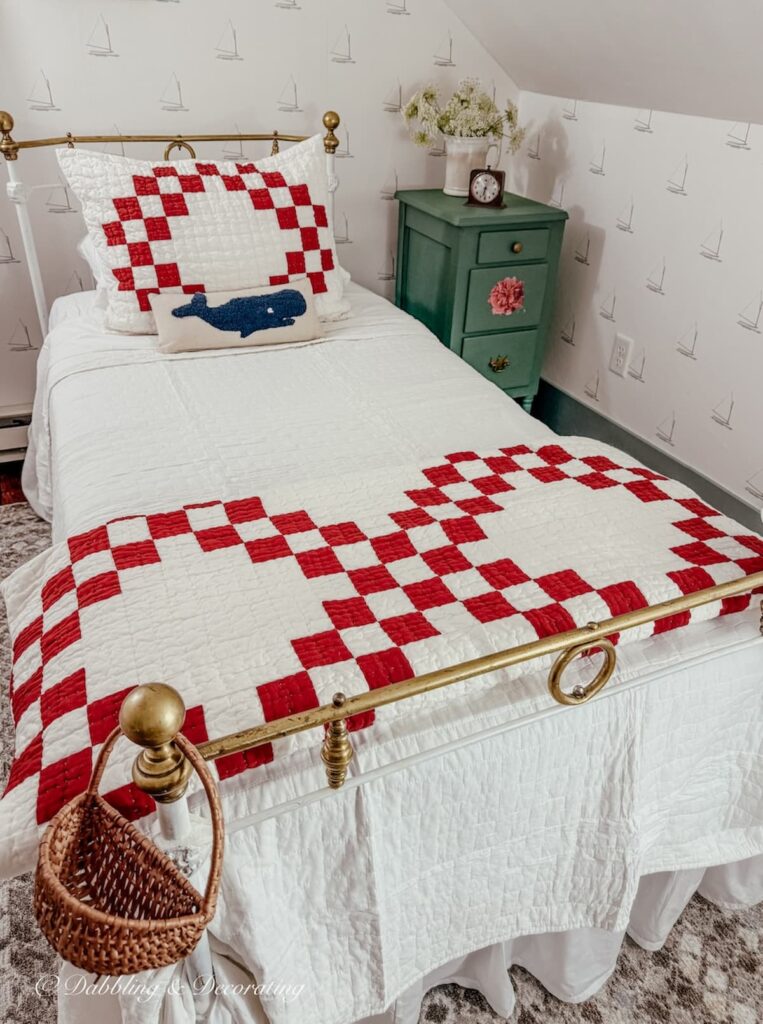 Twin antique wrought iron bed with red and white quilt and sham with painted nightstand makeover in green with queen anns lace in ironstone pitcher.