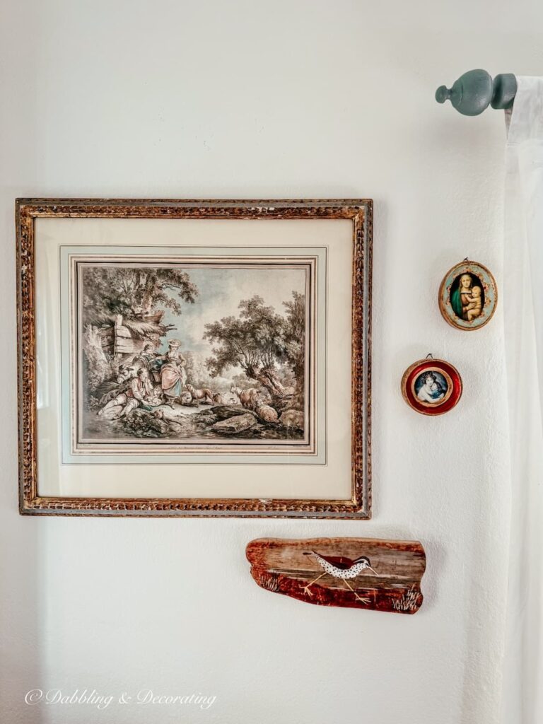 Benjamin Moore's Simply White Walls in bedroom with small framed paintings and custom historic blue-gray paint curtain rod and white curtain.