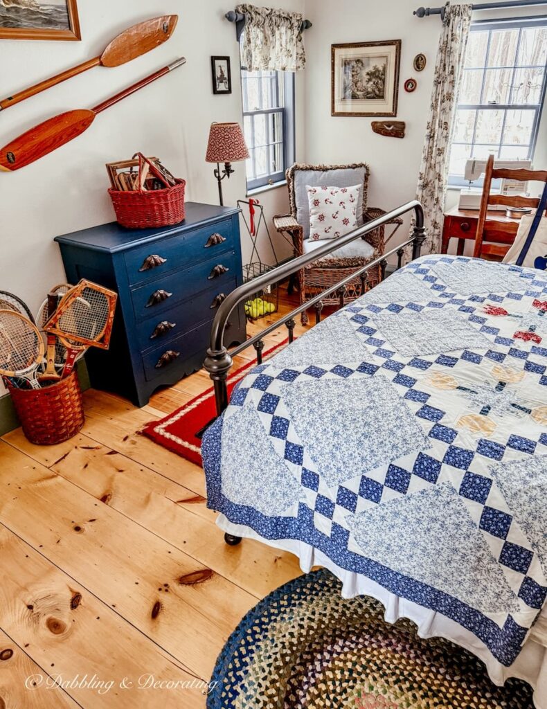 Small guest bedroom in coastal Maine home with vintage charm and coastal styling with old quilt, braided rugs and blue paints.