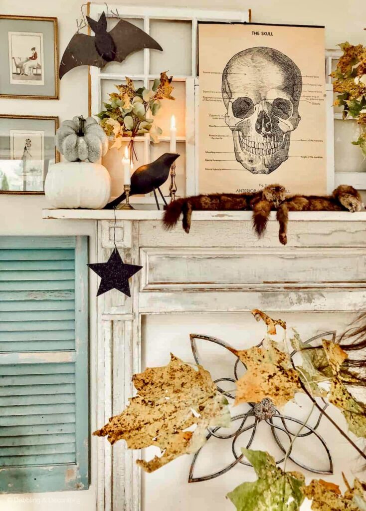 Vintage Halloween ideas with mantel with academic skeleton poster, minks, black bats, crows, and stars, foliage leaves and old shutters and layered salvaged windows.
