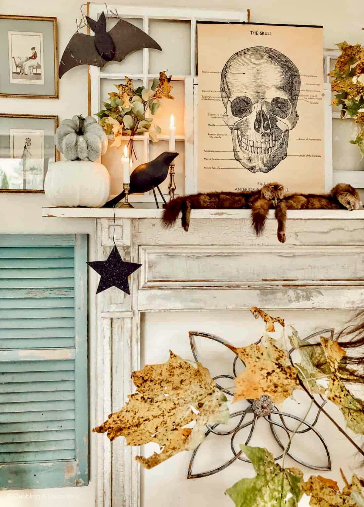 Vintage Halloween ideas with mantel with academic skeleton poster, minks, black bats, crows, and stars, foliage leaves and old shutters and layered salvaged windows.