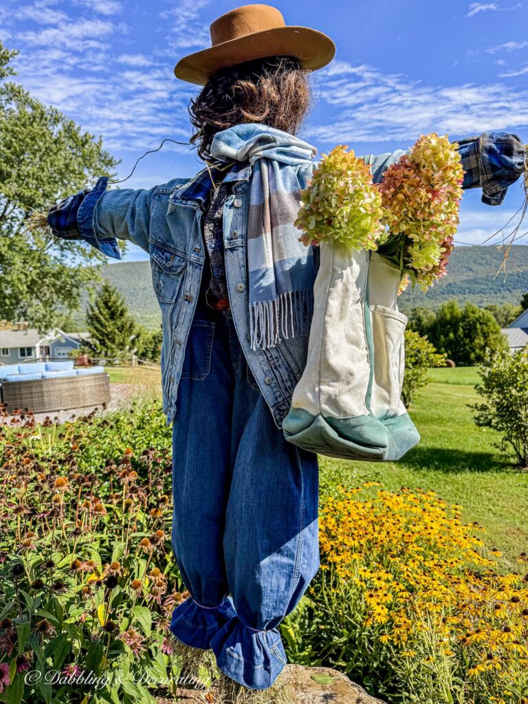 My fall scarecrow layered in thrifted blue jeans and a bag filled with hydrangeas in the mountains of Vermont.
