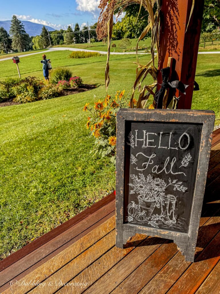 Bistro chalkboard with Hello Fall art work on colorful fall porch with mountain views at home in Vermont.