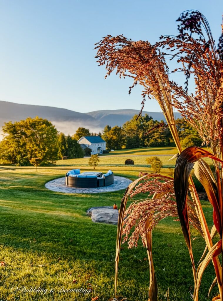 Corn Broom Stalks on colorful front porch beam with mountain views and golden morning sunlight.