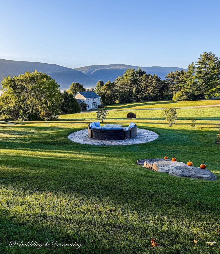Mountain views with fire pit with sectional seating off a colorful fall porch in Vermont.