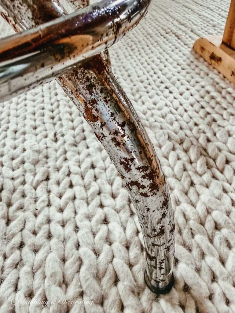 Close up of rust on leg of an antique drafting stool.