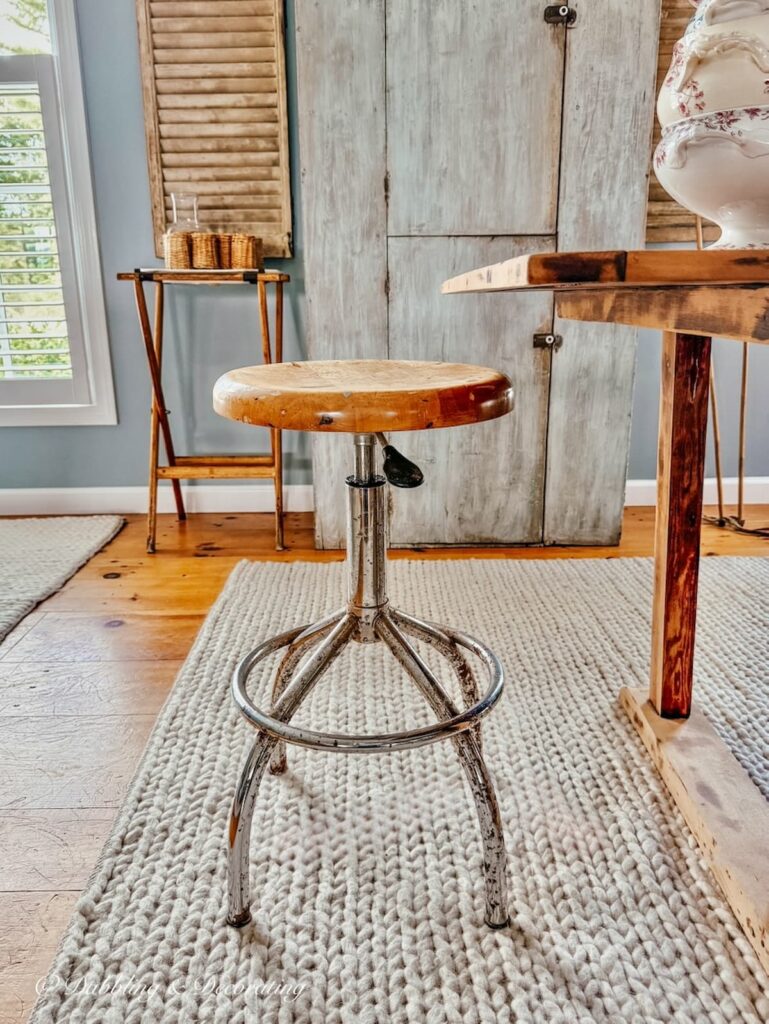 Rusty antique drafting stool in collected vintage scullery.