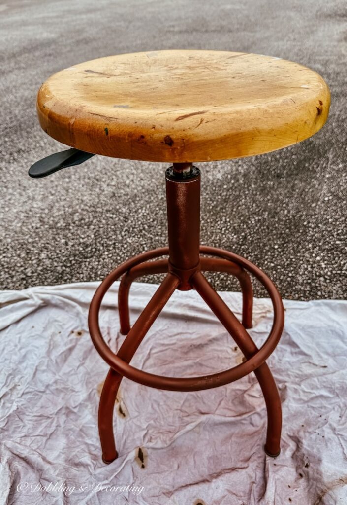 Antique drafting stool restoration with Rust-Oleum Rusty Metal Primer in brown applied and drying.