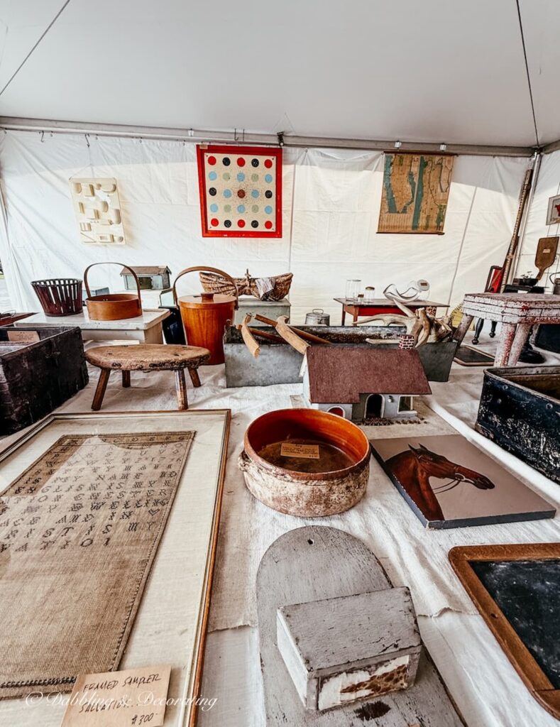 Vintage booth display with beautiful pieces inside a tent at the Taconic Antiques Fair