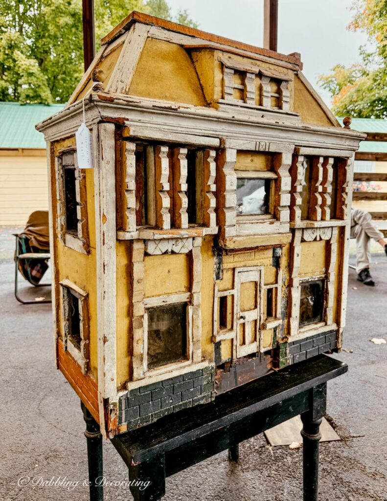 Haunted styled large yellow doll house at a vintage booth inside the Taconic Antiques Fair.