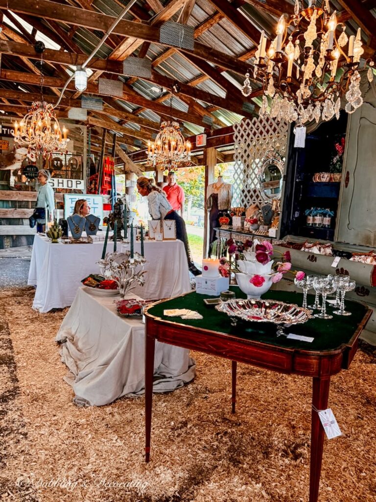 Country Living Fair vintage booth with chandeliers and elegant displays.