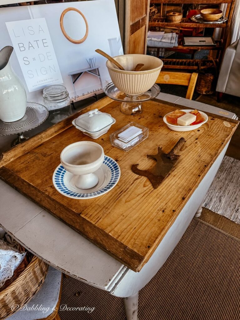 old Belgian table-edge cutting board on white farmhouse table in a vendor's booth at the Country Living Fair.