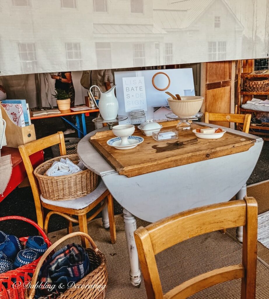 old Belgian table-edge cutting board on white farmhouse table in a vendor's booth at the Country Living Fair.