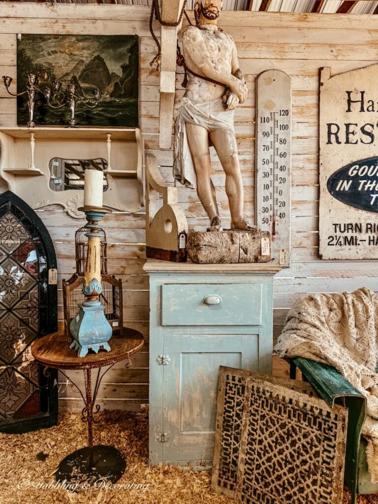 Antique vendor booth display with architectural salvage and statues at Country Living Fair.
