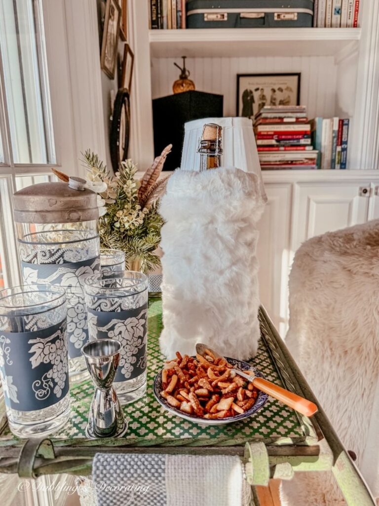 White hand muff as a wine cover on a vintage bar cart.