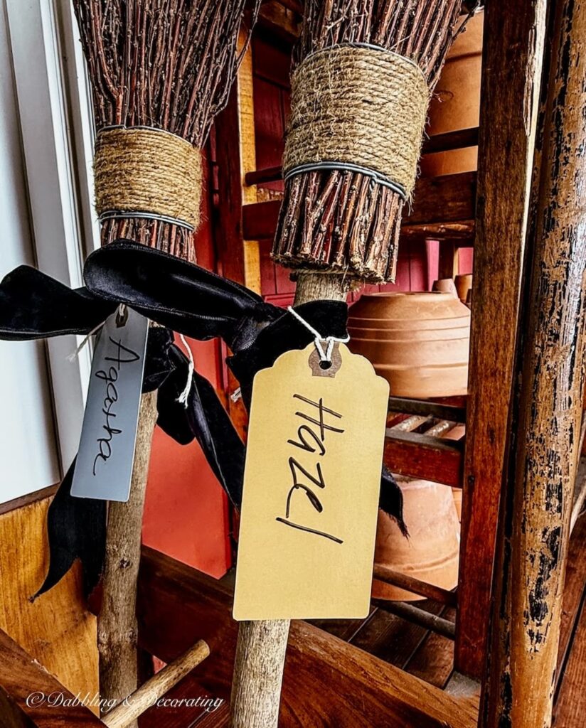 Two witches brooms with luggage tags that say Hazel and Agatha in a Halloween Witch Porch decor ideas.