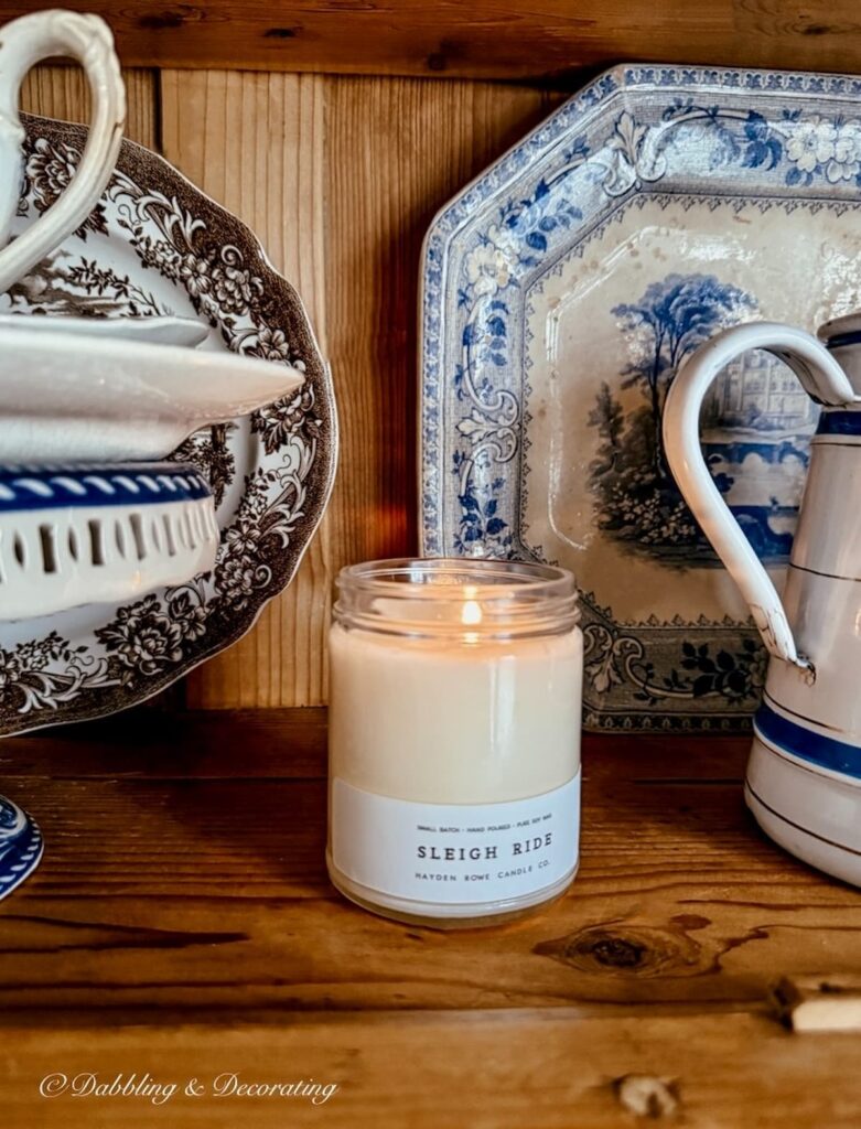 Sleigh Ride Vermont candle by Hayden Rowe Candles in antique pine hutch with collected transferware dishes for a cozy Sunday home vibe.