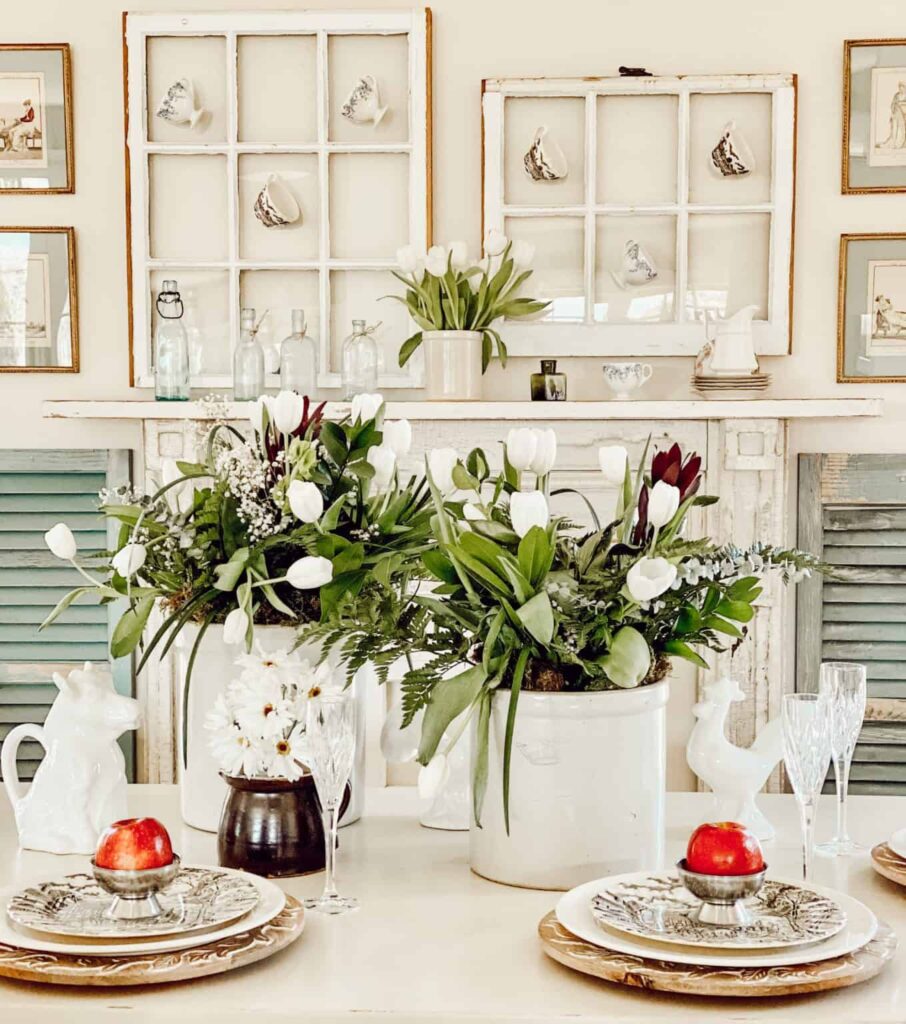 Vintage crock decorating ideas with floral arrangements using white tulips and greenery as table centerpieces.